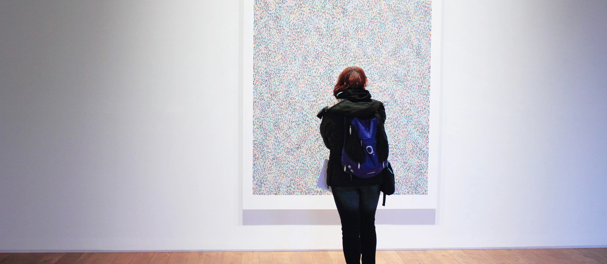 Frau schaut ein Bild in einer Ausstellung an