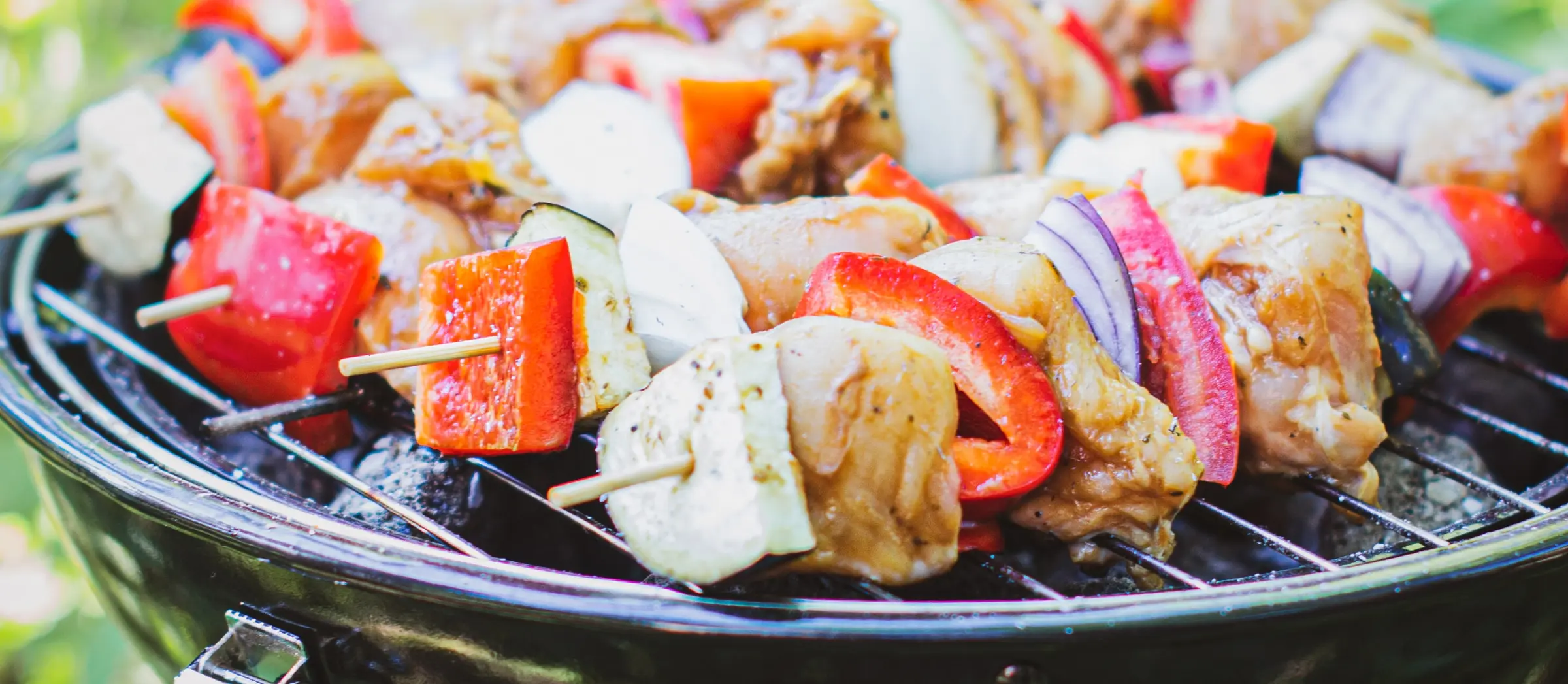 Grillspieße auf einem Gitterrost eines Minigrills