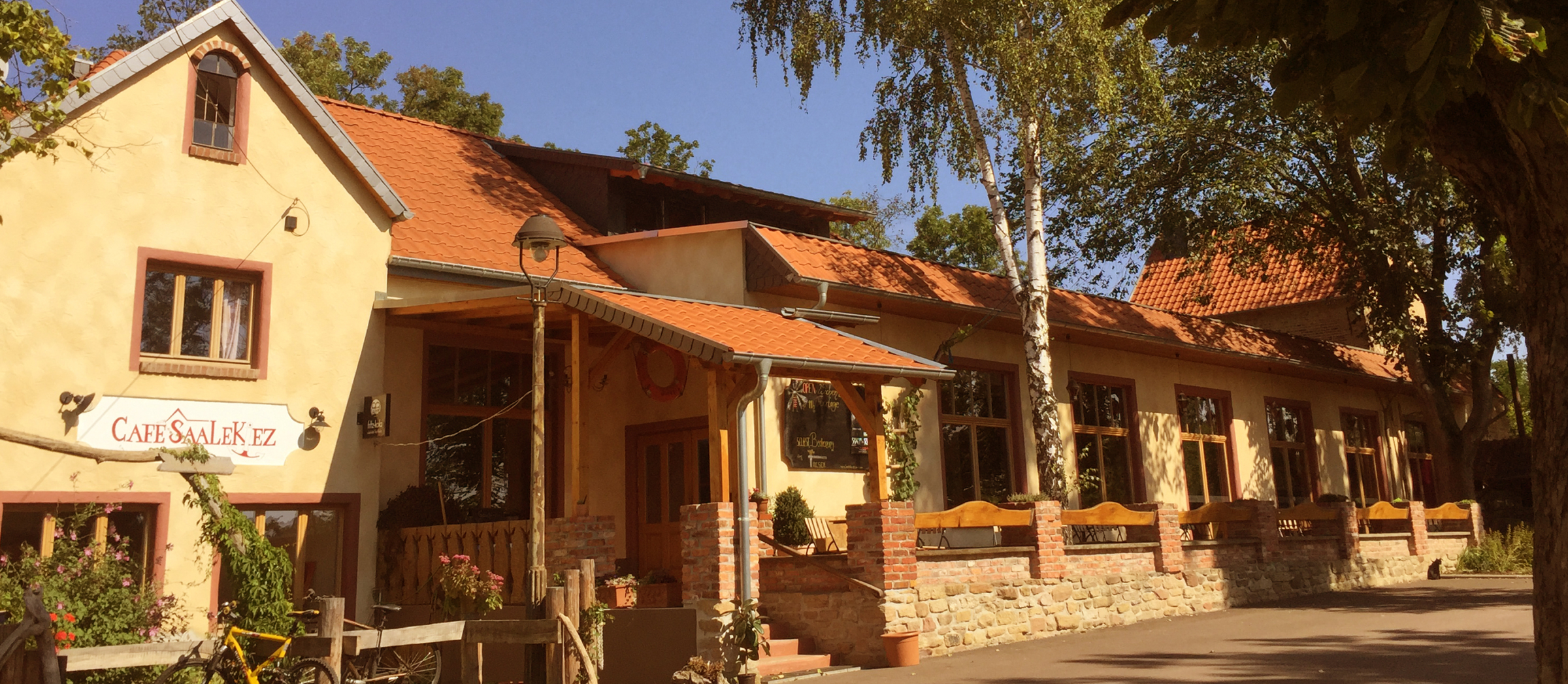 Das Café Saalekiez ist von außen zu sehen und wird von der Sonne angestrahlt.