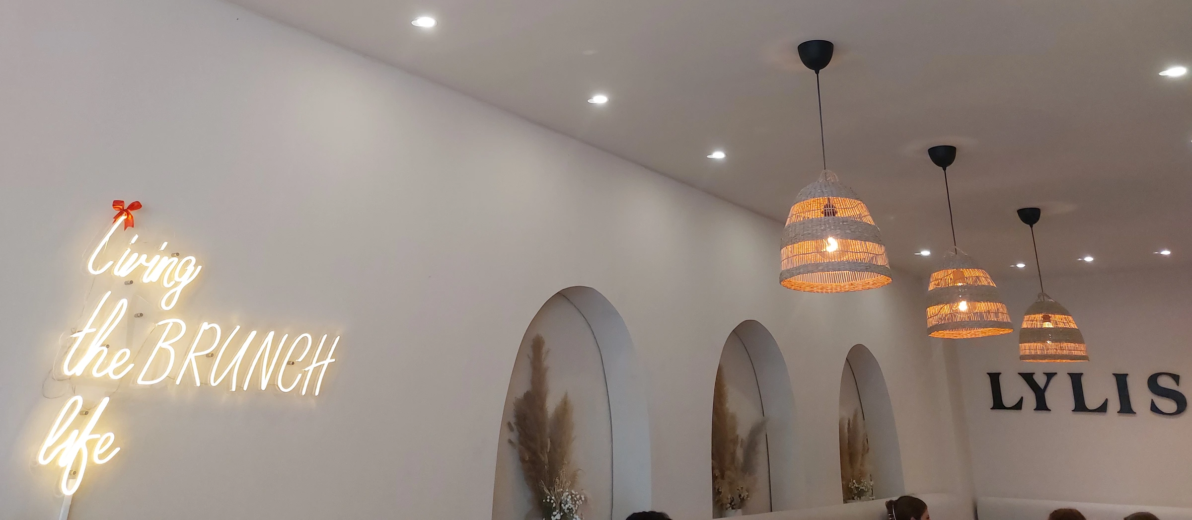 Zu sehen ist das Lylis Café von inen: Ein leuchtender Schriftzug ziert die Wand: "living the Brunch life"