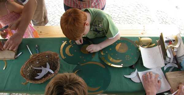 Kinder beim Anfertigen einer selbstgebastelten Kopie der Himmelsscheibe von Nebra.