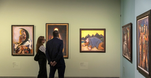 Ansicht der Ausstellung „Karl Hofer. Zwischen Schönheit und Wahrheit“ im Kunstmuseum Moritzburg Halle (Saale). Zwei Personen stehen vor Gemälden des Malers Karl Hofer. 