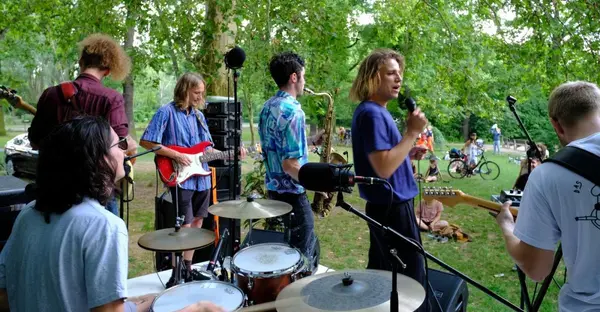 Junge Musiker musizieren auf einer Bühne unter freiem Himmel.