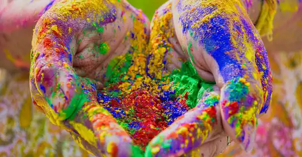 Hände mit buntem Farbpulver