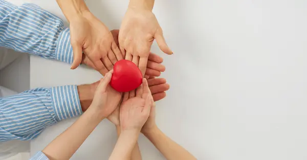 Hände halten ein rotes Herz