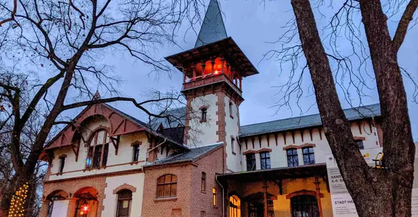 Das Peißnitzhaus von außen: ein historisches Gebäude mit einer Turmspitze ragt in den Himmel.