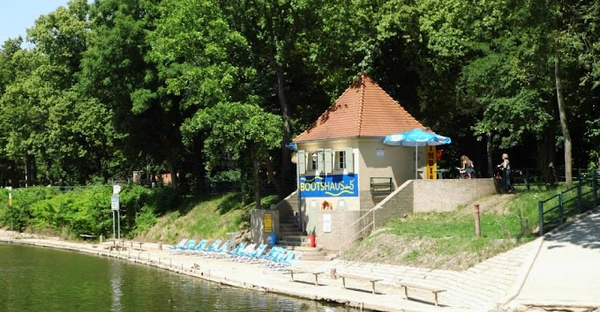 Ein kleines Häuschen steht am Ufer der Saale. Davor befinden sich Liegestühle mit Blick auf den Fluss.