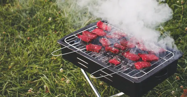 Auf einem kleinen Grill liegen Steaks.