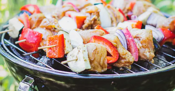 Grillspieße auf einem Gitterrost eines Minigrills