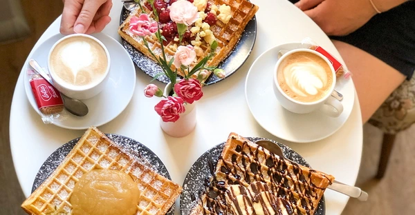 Gedeckter Kaffeetisch mit Kaffee und Waffeln