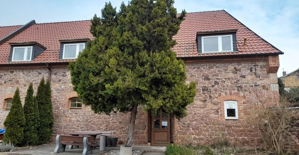 Außenansicht der Schleuse: ein alters Backsteingebäude ist zu sehen, davor steht ein Baum.