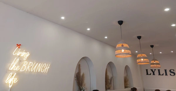 Zu sehen ist das Lylis Café von inen: Ein leuchtender Schriftzug ziert die Wand: "living the Brunch life"