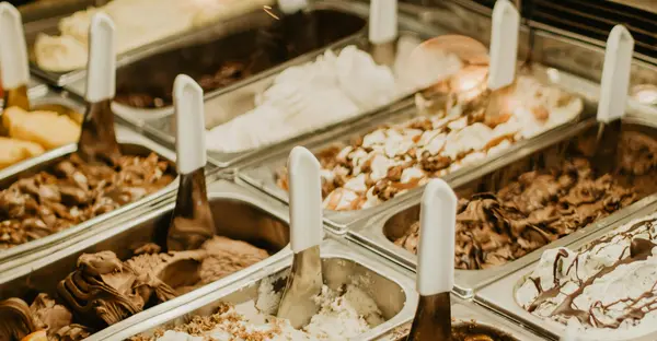 Verschiedene Eissorten in Eiscremebehältern an einer Eistheke