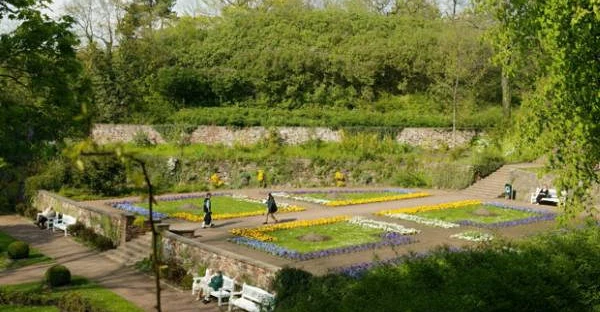 Blick auf den Amtsgarten: Ein gepflegter Landschaftsgarten ist umgeben von einer grünen Kulisse.