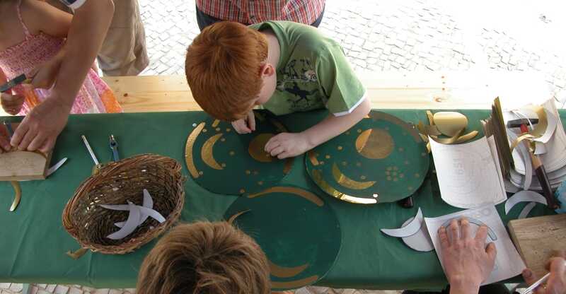 Kinder beim Anfertigen einer selbstgebastelten Kopie der Himmelsscheibe von Nebra.