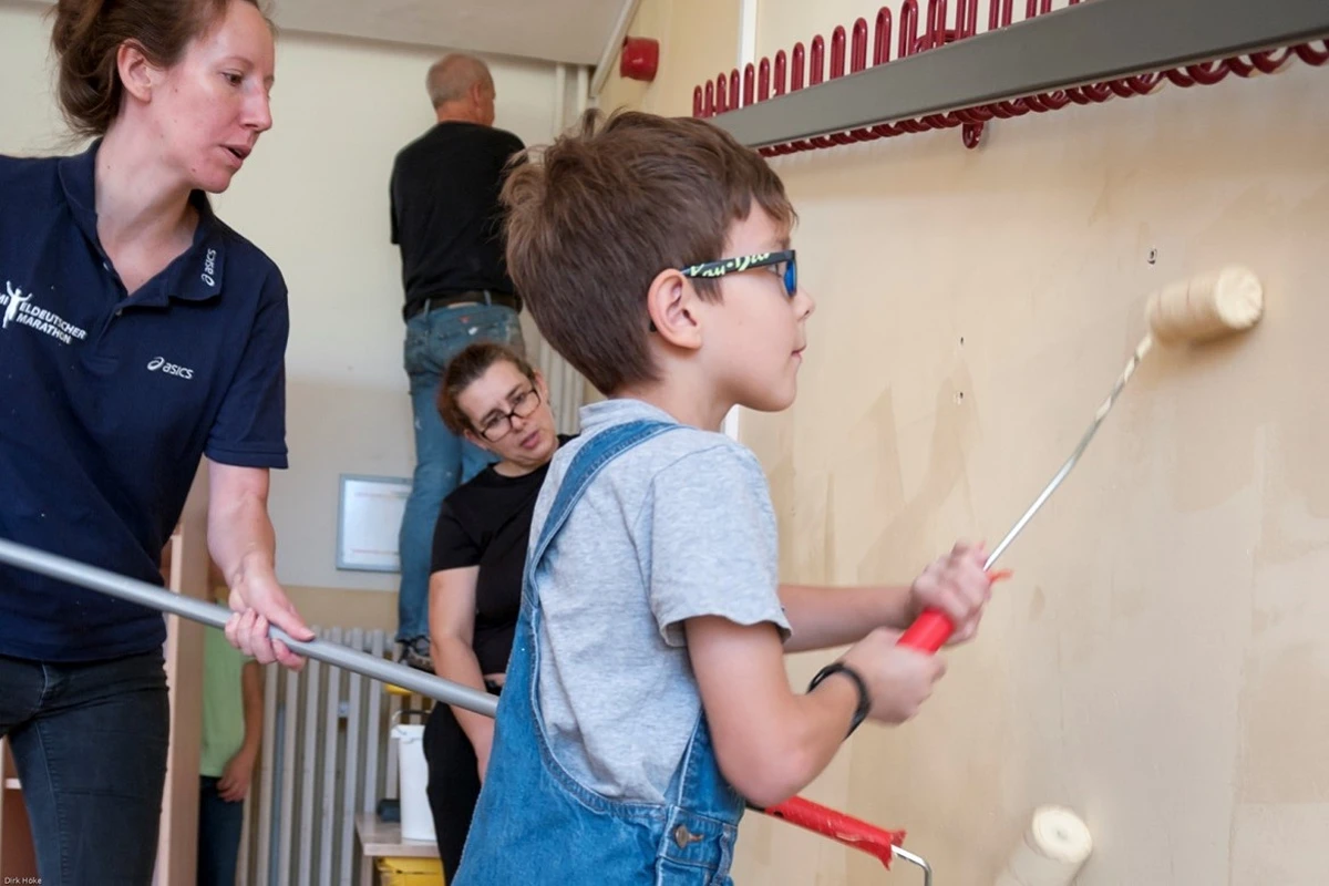Ein kleiner Junge streicht eine Wand