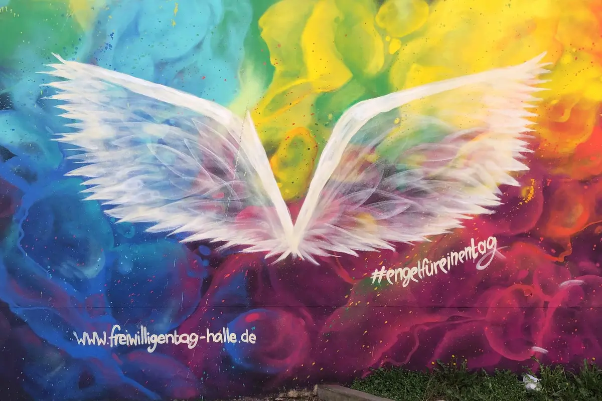 Ein Graffiti von Engelsflügeln auf bunten Hintergrund